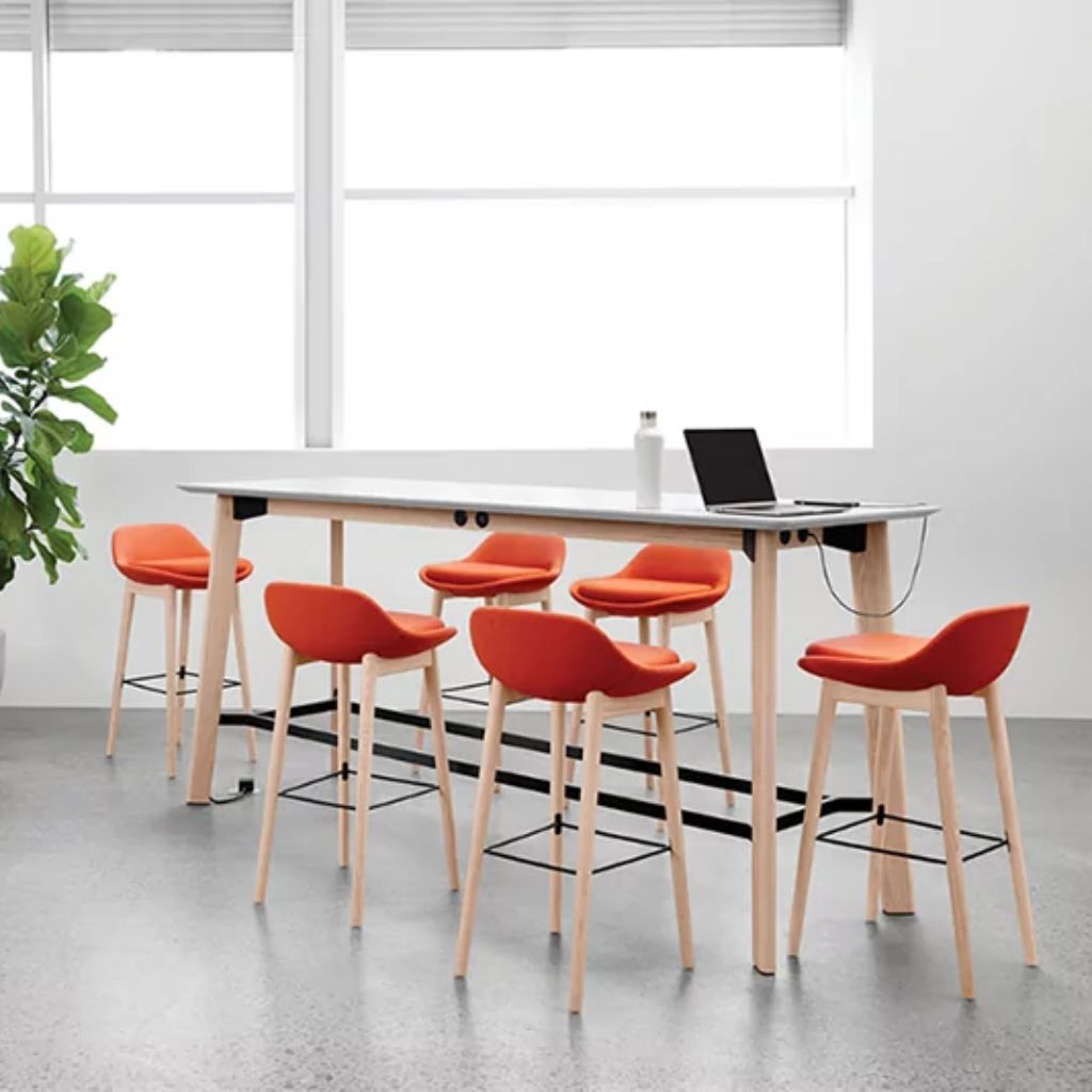 Standing meeting setup with tall tables and presentation screen